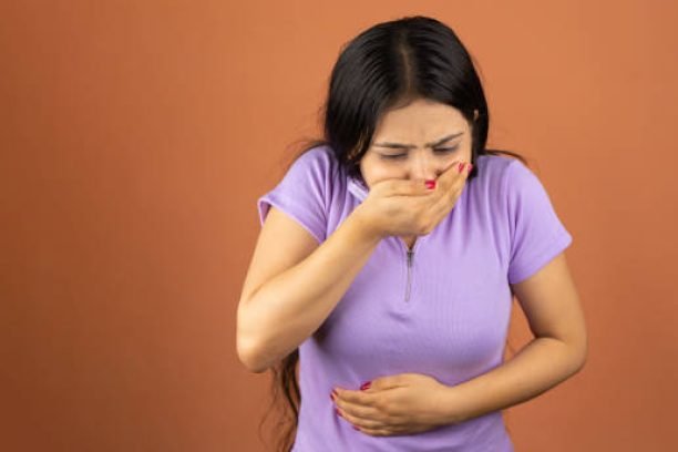 Woman suffering from stomach ache and nausea on color background